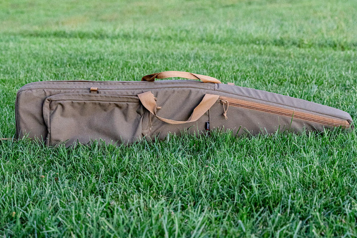 Rifle bag in grass with rifle inside. Armageddon Gear 52 Inch Precision Rifle Case - Sharps Mountain Outdoor Gear - Pigg River Precision