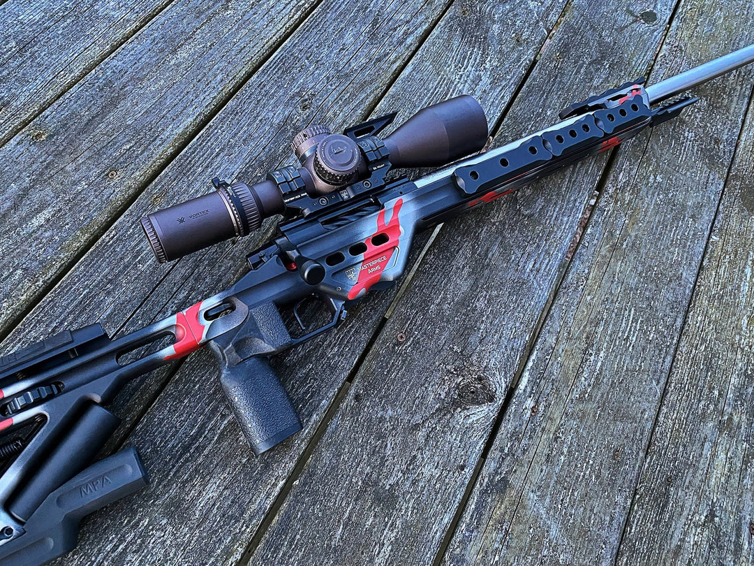 Competition rifle laying on wood planks. Barrel of rifle has grey ops barrel weights.  Gray Ops M-Lok External Weights - Sharps Mountain Sharpsmountain.com 